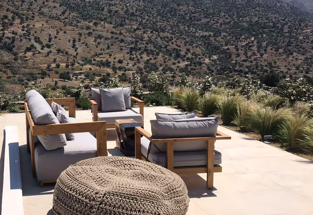 The outdoor lounge of villa illios consists of two comfortable armchairs with a sofa, a straw pouf and α carved wooden table. Perfect view of cretan mountains and cretan sea. Enjoy the most breathtaking sunset